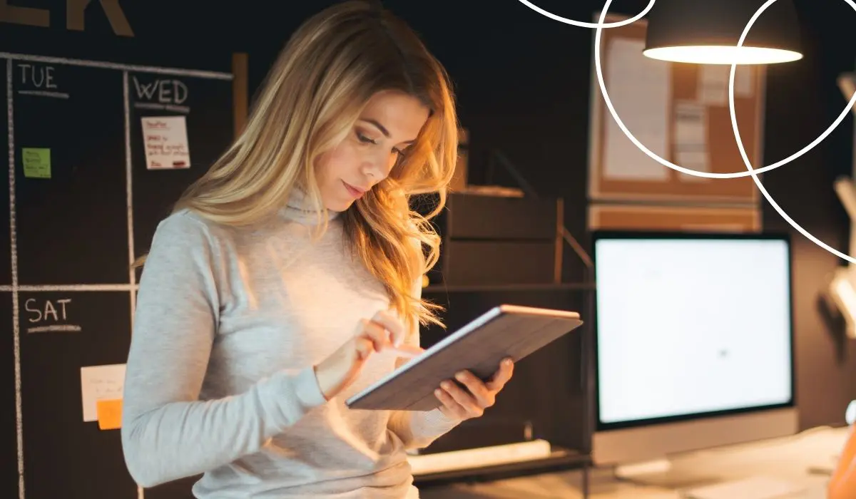 Junge Frau arbeitet konzentriert auf einem Tablet.
